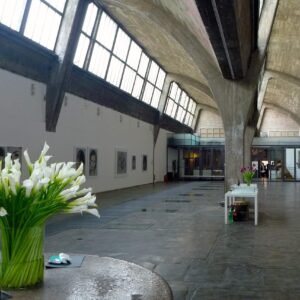 Beijing art gallery with vaulted ceilings and natural light, with vase of white flowers in the foreground.