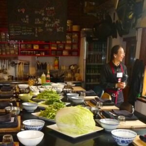 Delicious Chinese cooking class with fresh vegetables and a friendly chef instructor in a warm, inviting kitchen environment.