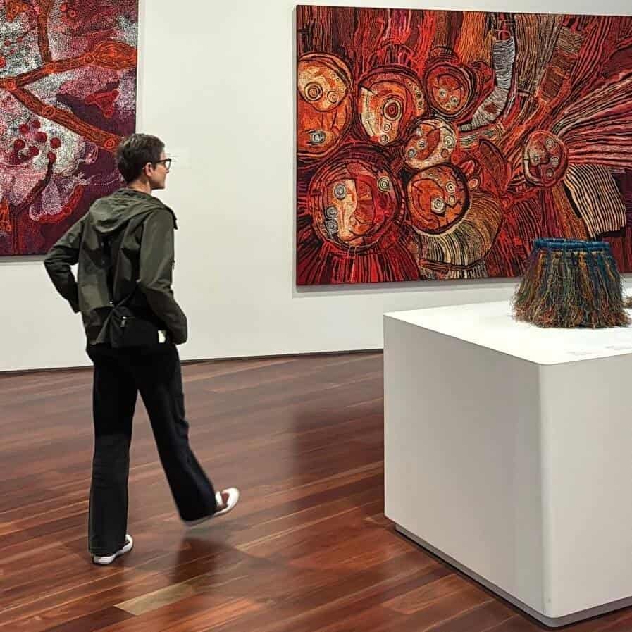 Colorful Aboriginal artwork on display at AGNSW, featuring rich reds and intricate textures, perfect for art lovers and travel enthusiasts exploring cultural destinations.
