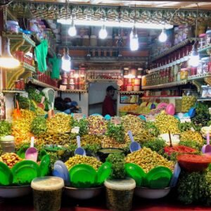 Vibrant Marrakech market stall featuring a wide variety of olives and pickles, with bright lighting and colorful containers, creating an inviting and lively shopping experience.